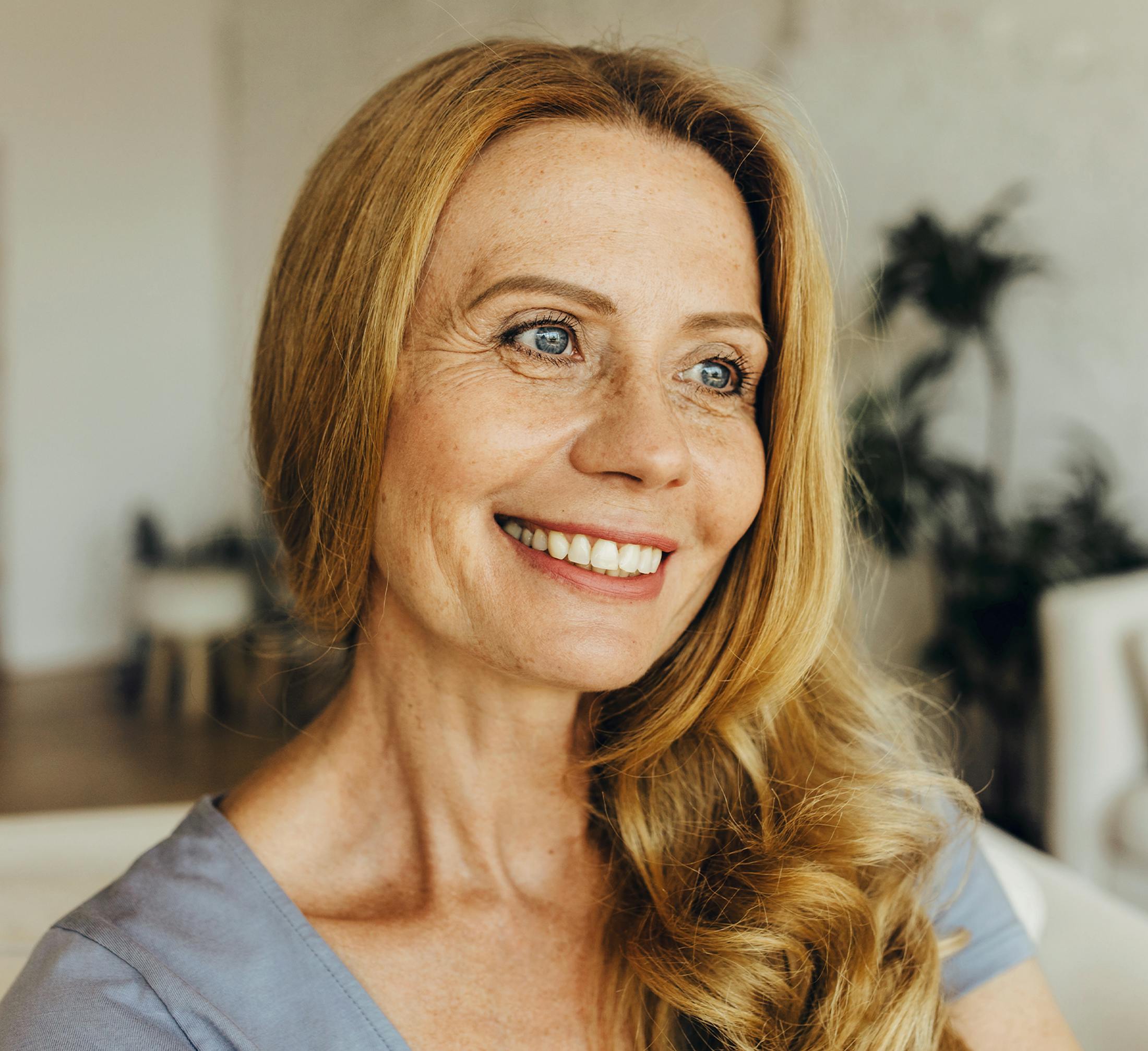 woman with long blonde hair over one shoulder looking forward