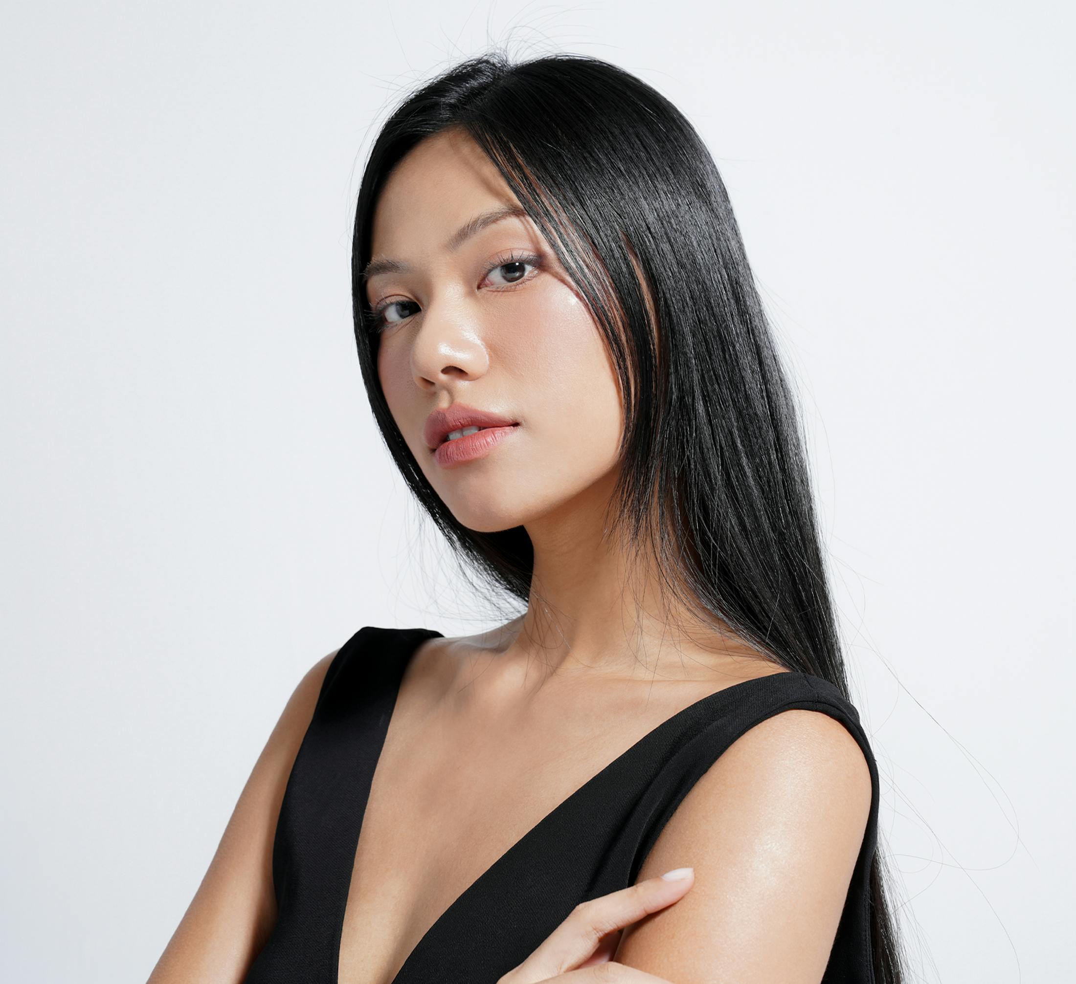 asian woman with long black hair, arms crossed wearing a black tank