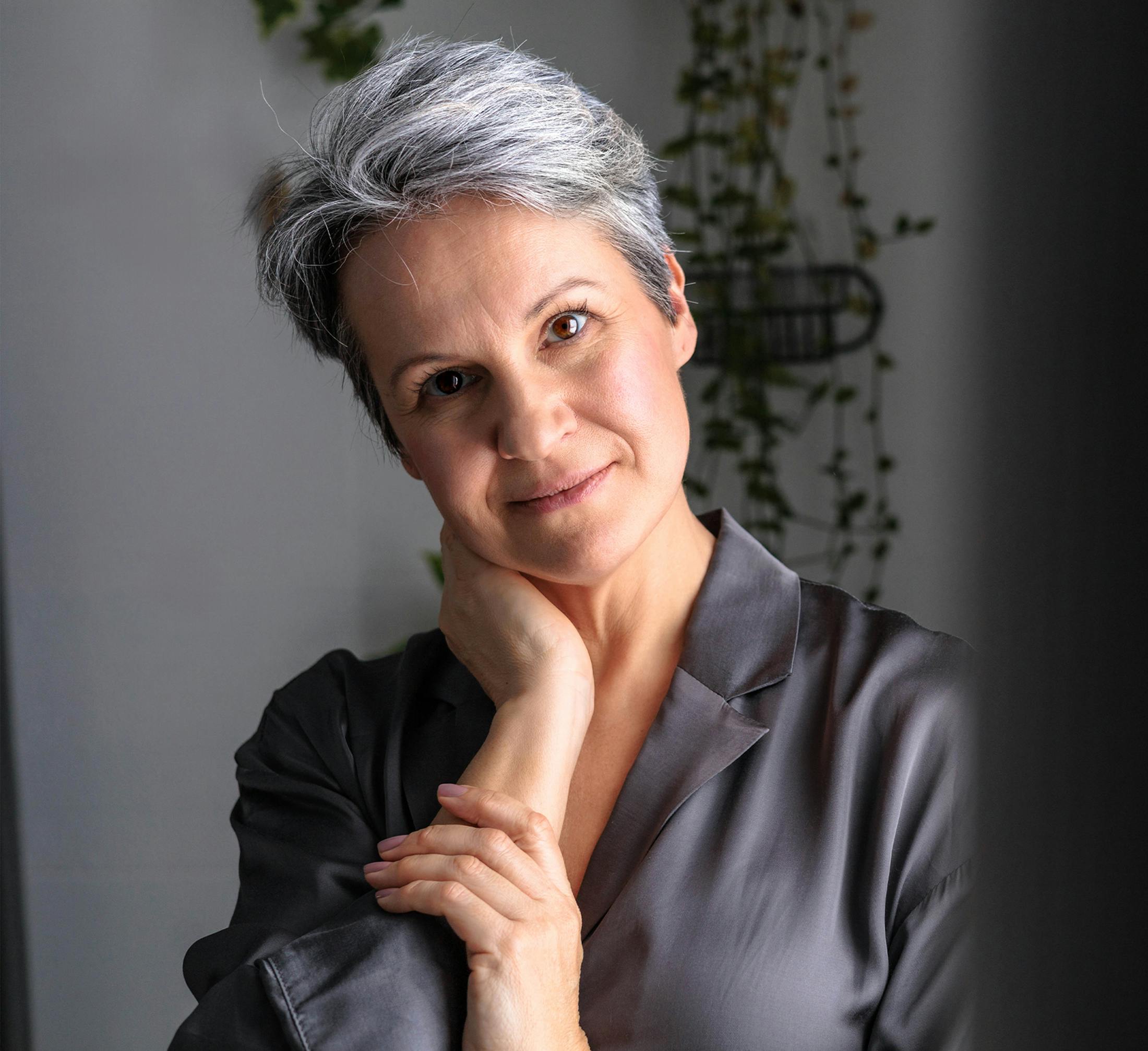 woman in purple silk shirt with her hand on her neck