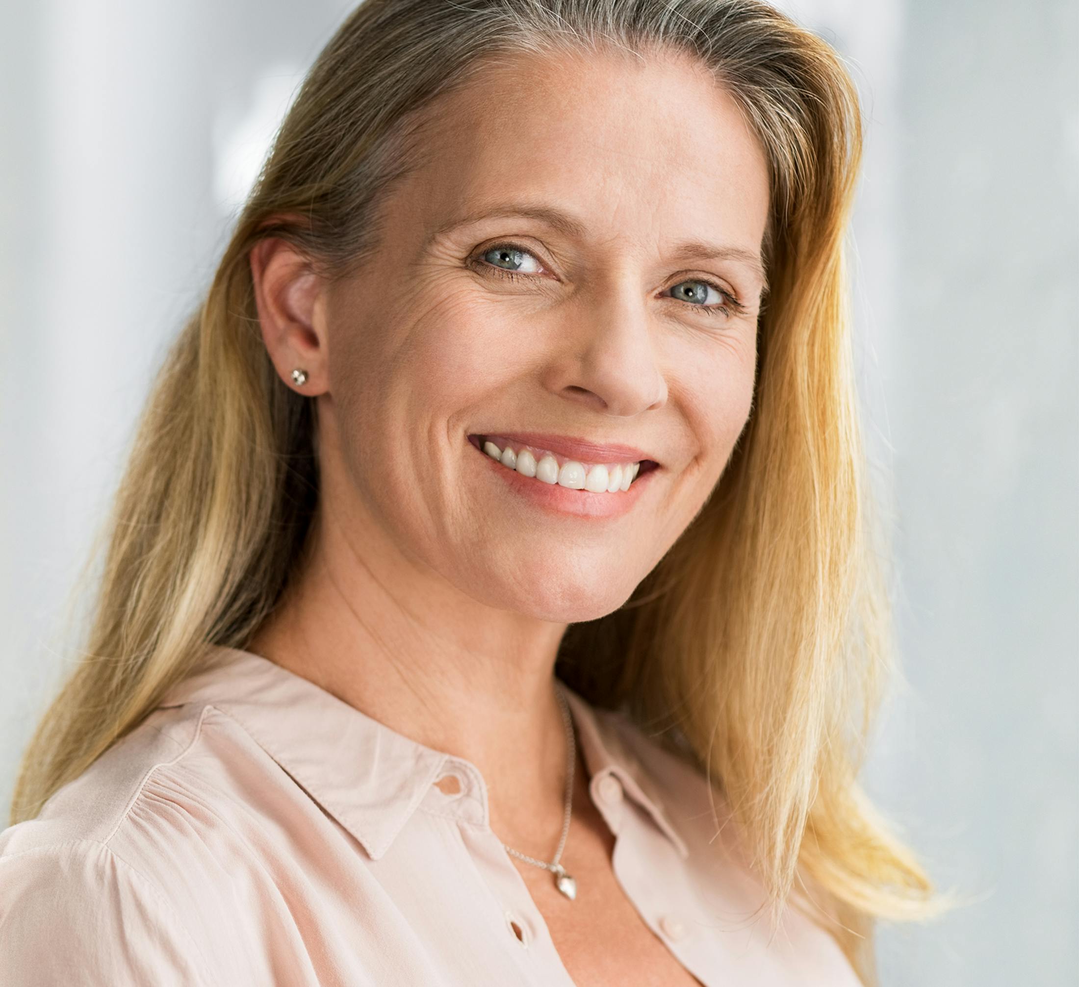 woman with long blonde hair and pink blouse