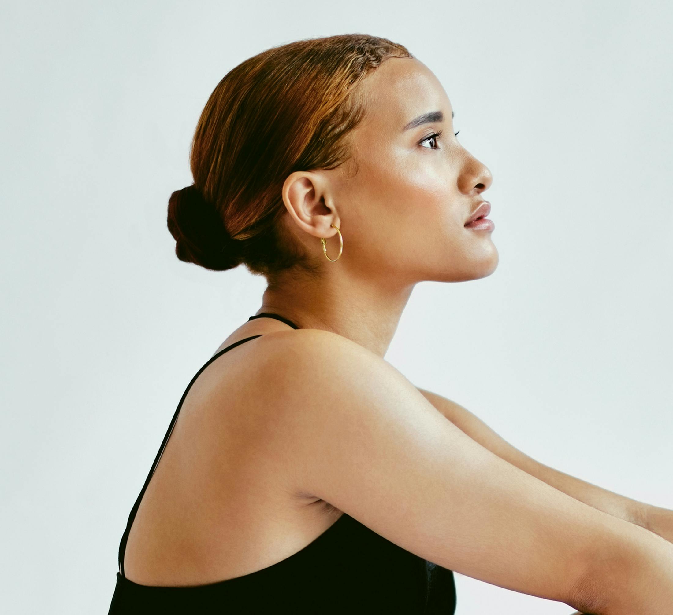 side profile of woman with her chin tilted up and hair in a bun