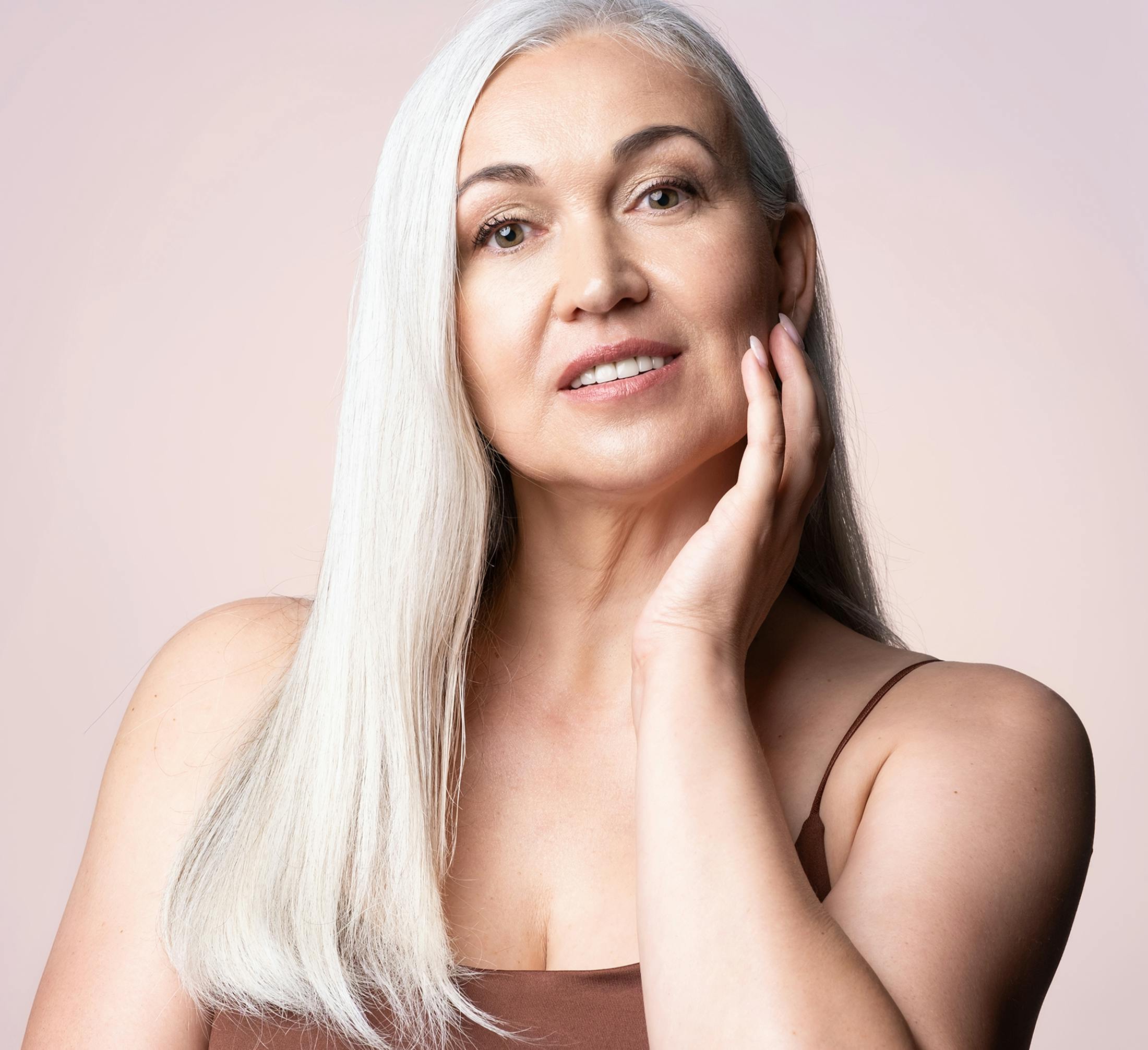 woman with long white hair and hand resting on jaw