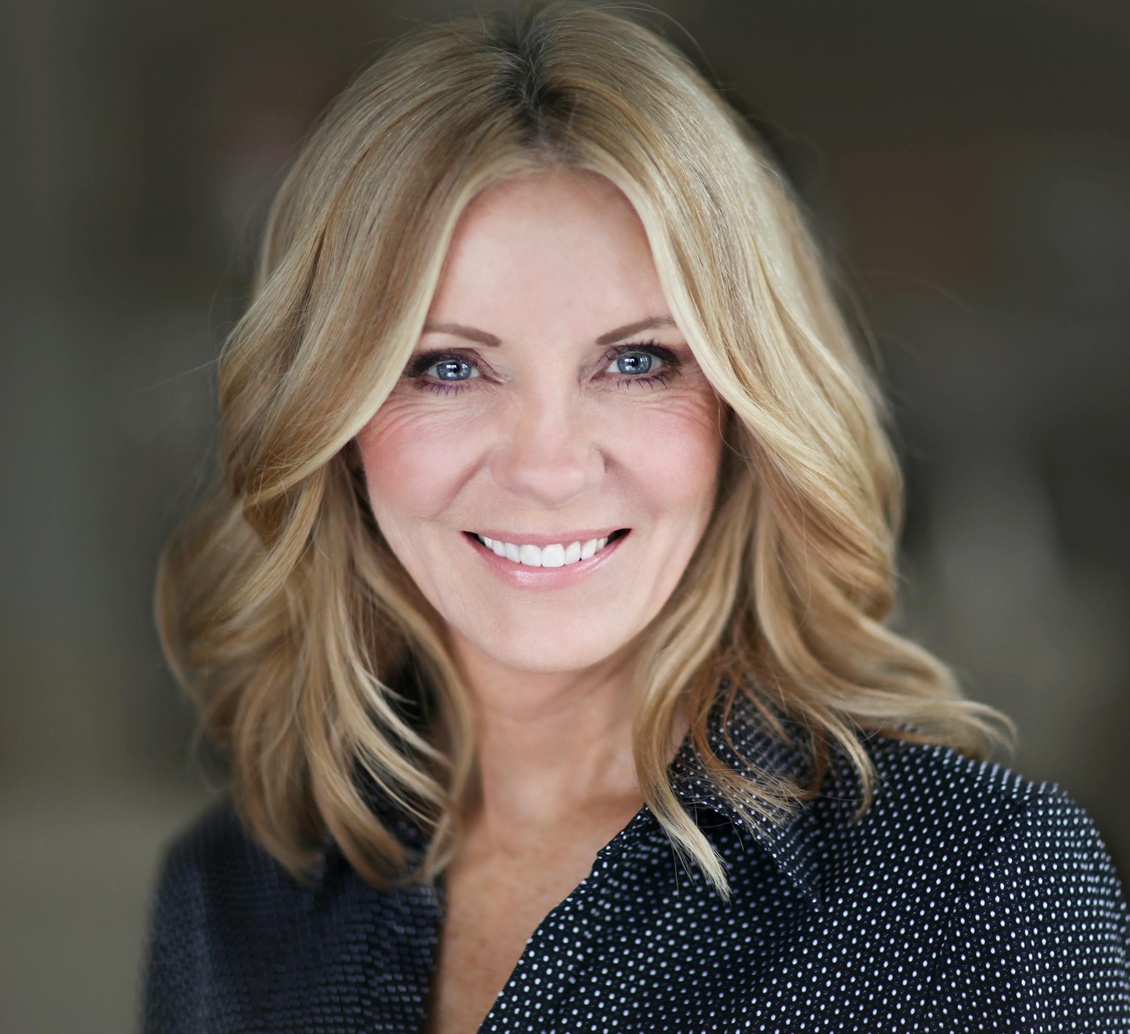 woman with blonde hair and pattern blue and white blouse
