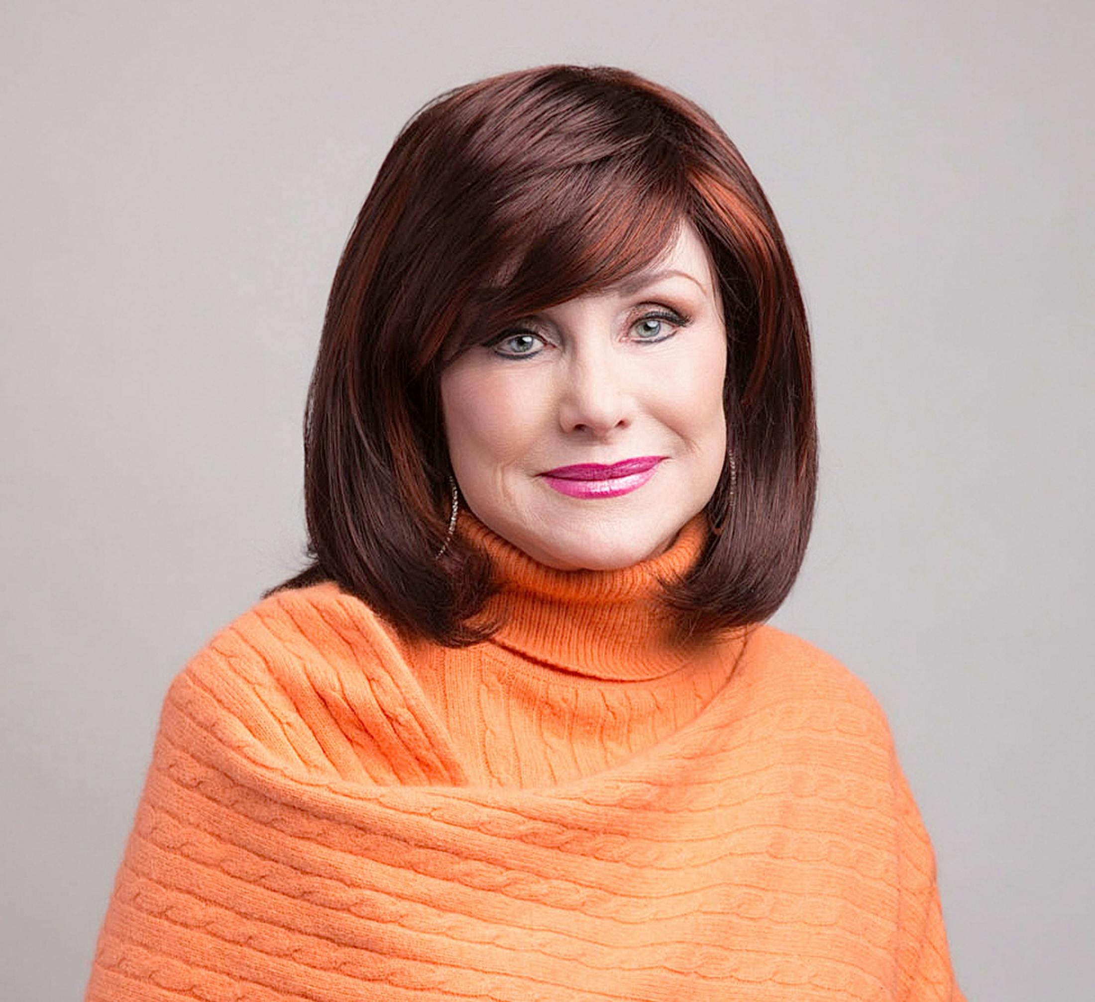 woman in bright orange sweater with short bob