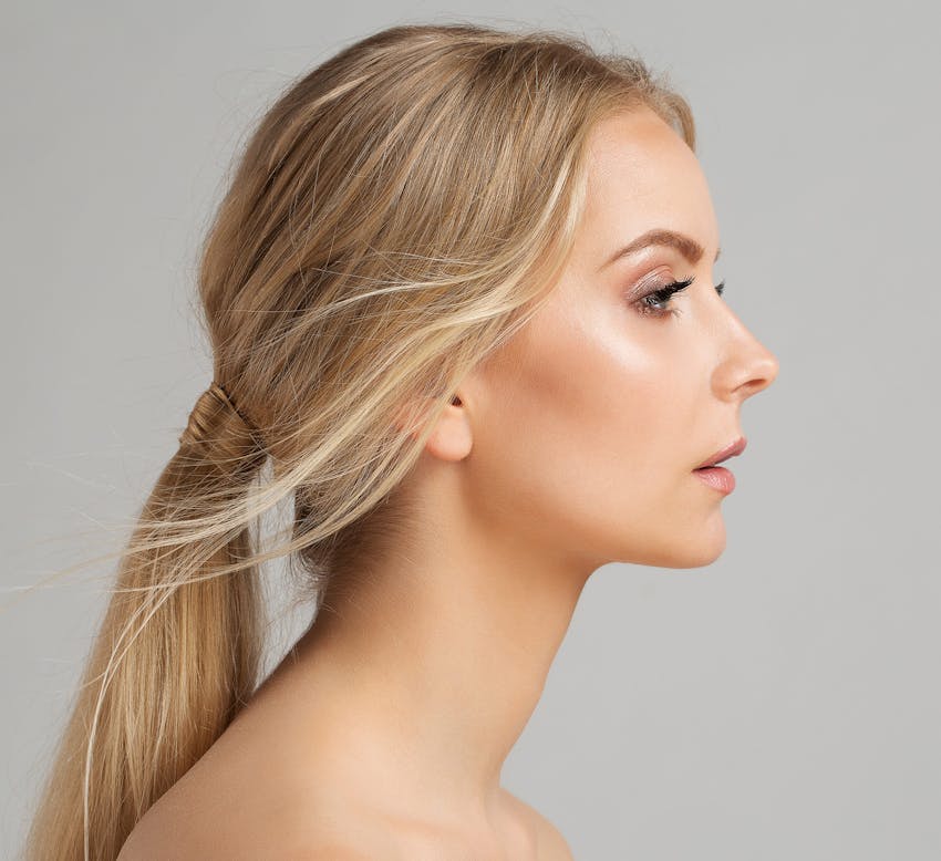 side profile of blonde woman with hair in a low ponytail