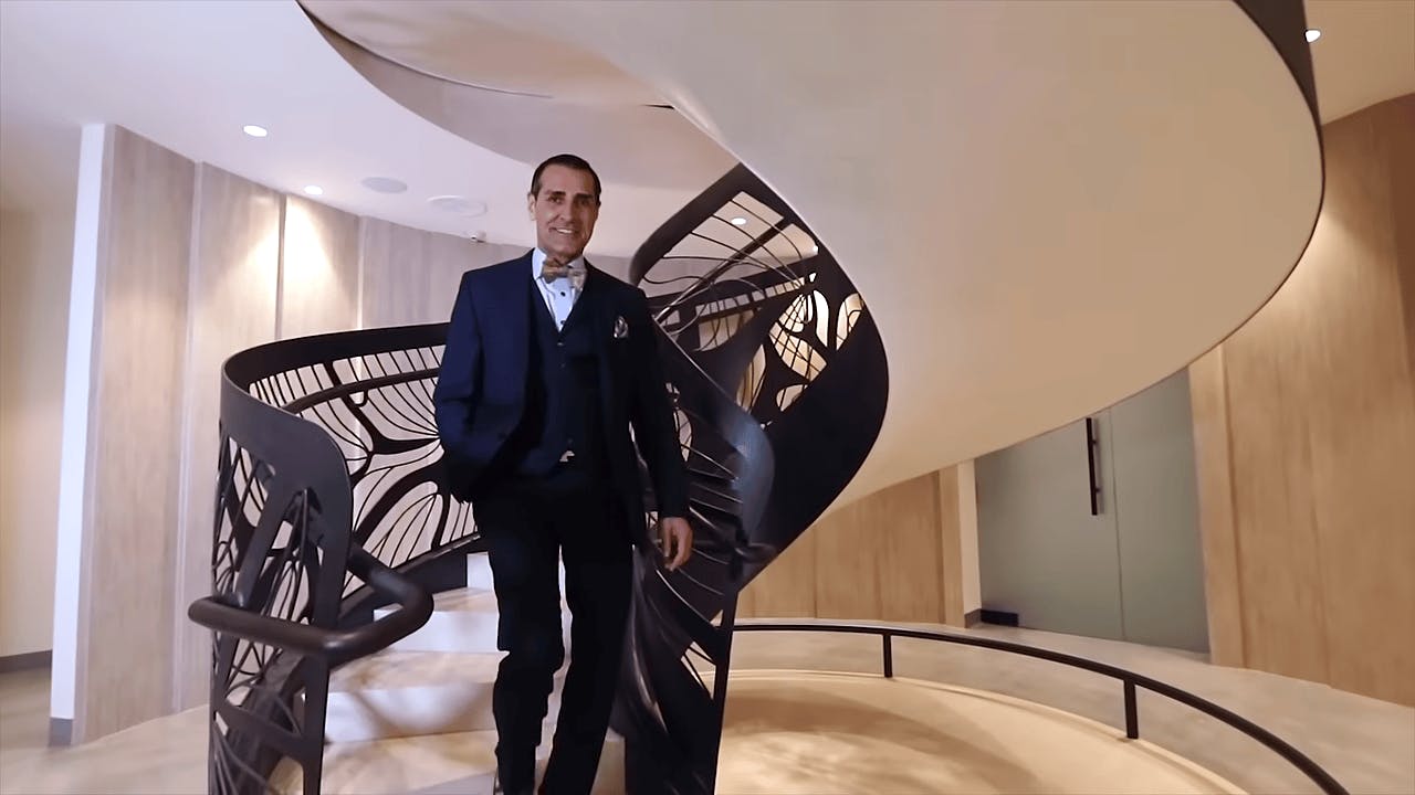 Dr. Kevin Sadati walking down stairs in his cosmetic surgery and aesthetic lounge