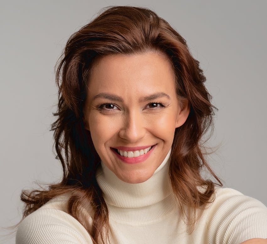 midleaged woman wearing a turtleneck looking at the camera