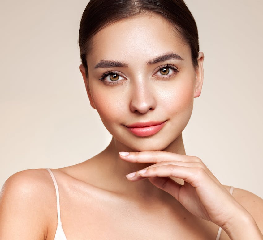 Woman with her hair up touching her face