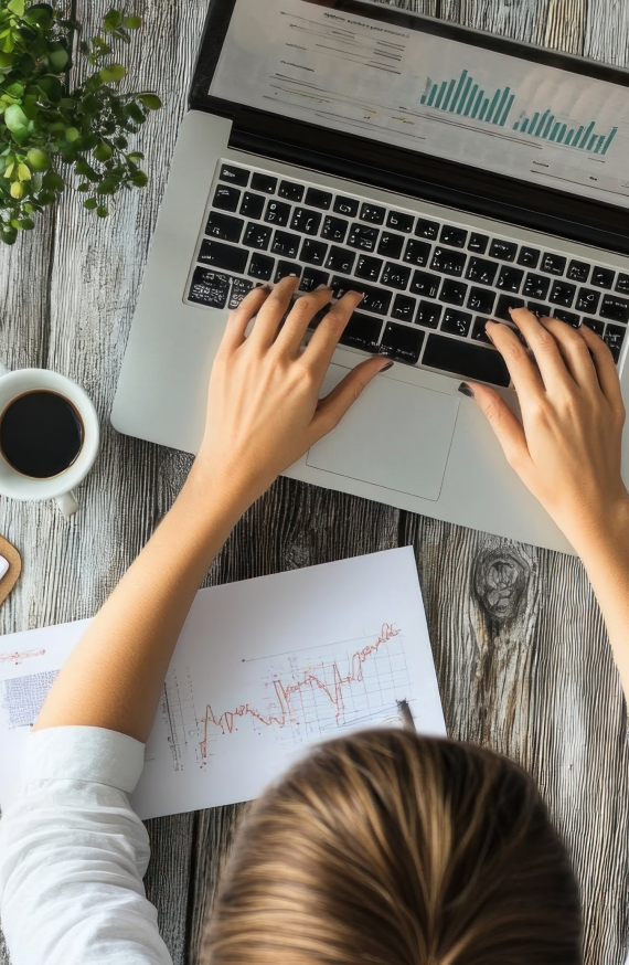 Osoba pracująca na laptopie i analizująca wykresy wyników kampanii marketingowych