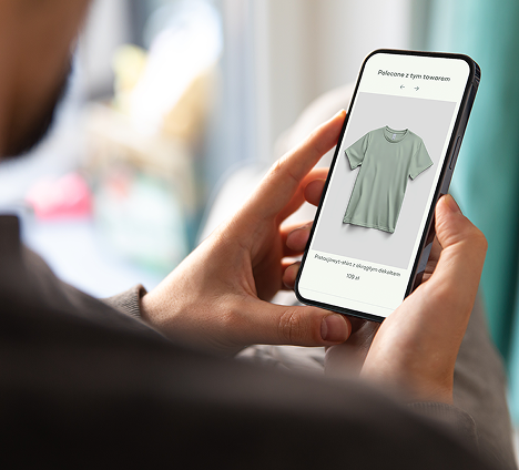 Osoba trzymająca smartfon z rekomendacją produktu na ekranie