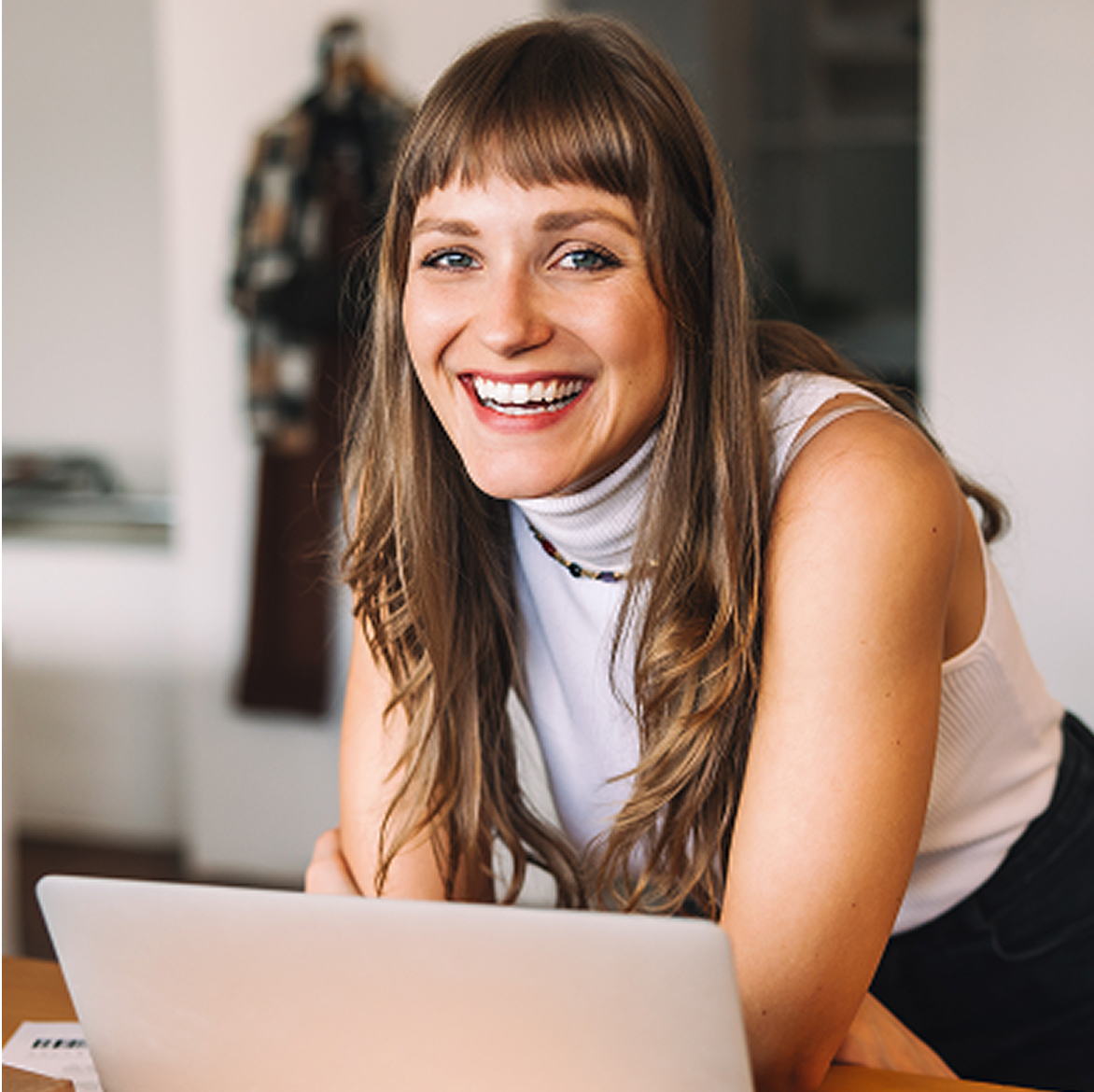 Program Partnerski i Lojalnościowy w sklepi internetowym Uśmiechnięta kobieta przy laptopie korzystająca z programów lojalnościowych i partnerskim