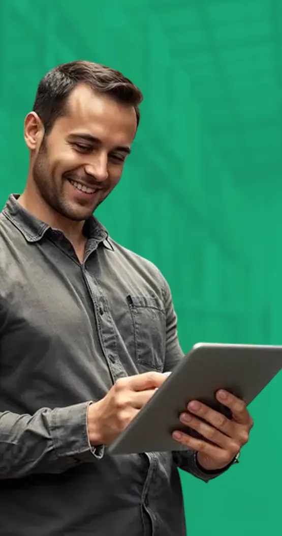 Uśmiechnięty mężczyzna wpatrzony w tablet