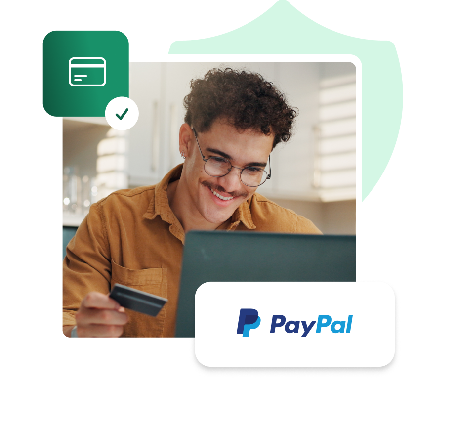 Mężczyzna trzymający kartę płatniczą i przeglądający laptop, logo PayPal, ikona zatwierdzonej płatności kartą