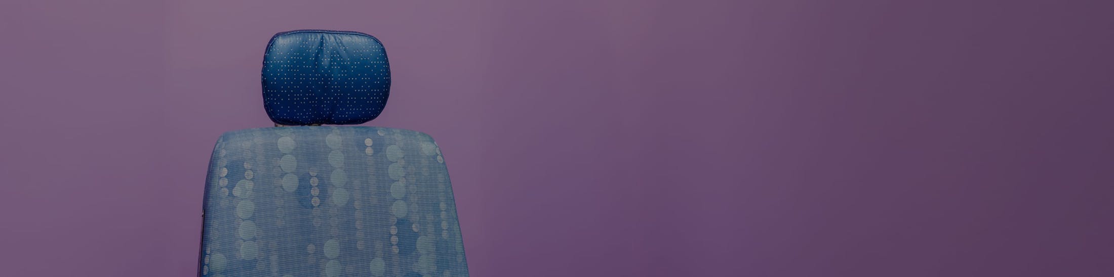 Patient chair against a purple background