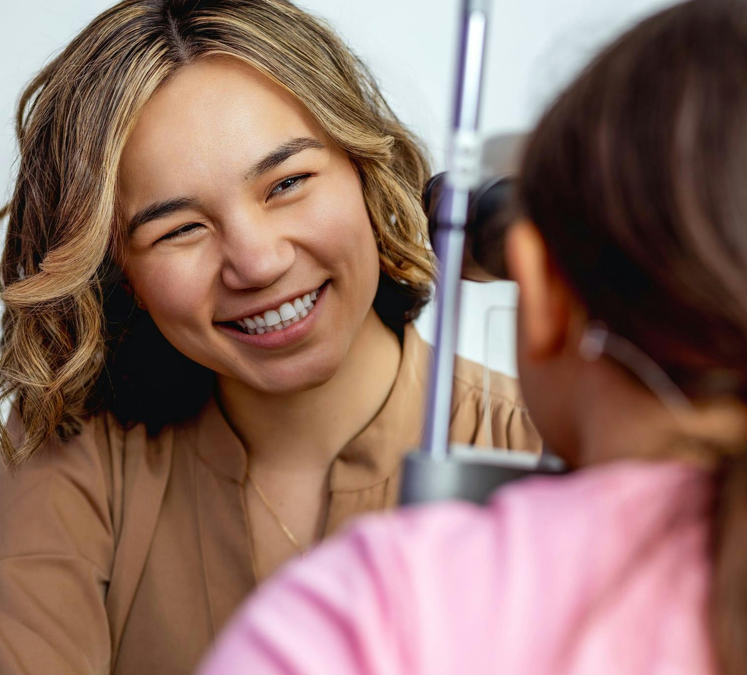 Docor smiling while giving an eye exam