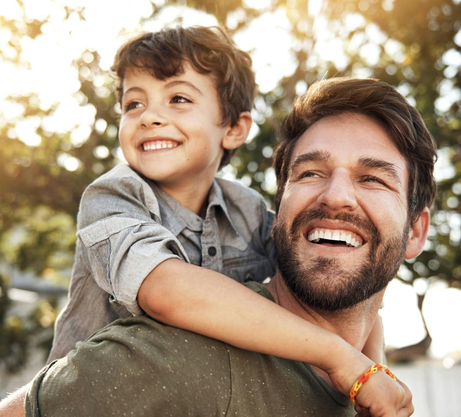 man giving a little boy a piggy back ride