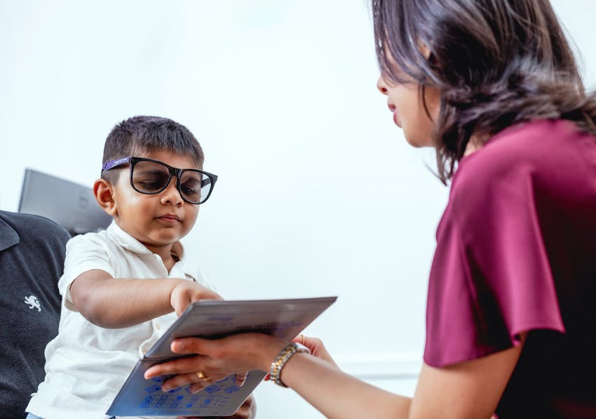 Kid pointing to a book during eye exam