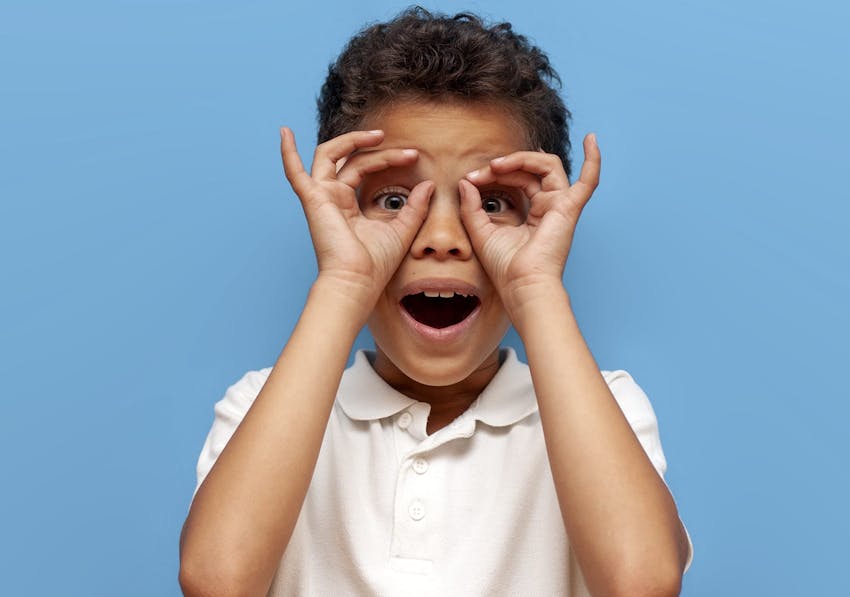 little boy with his hands on his face