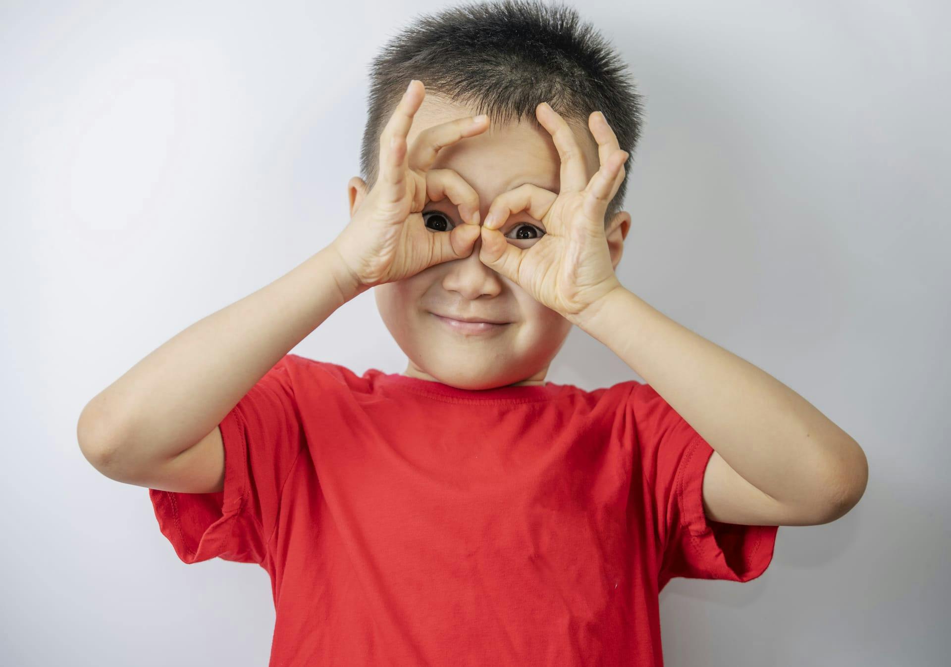 little boy covering his face