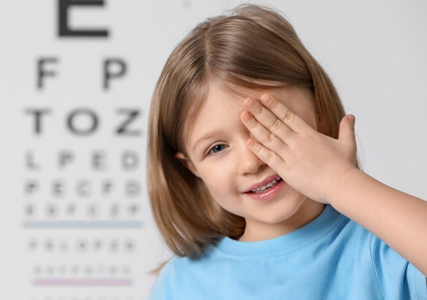 Kid covering her eye and smiling
