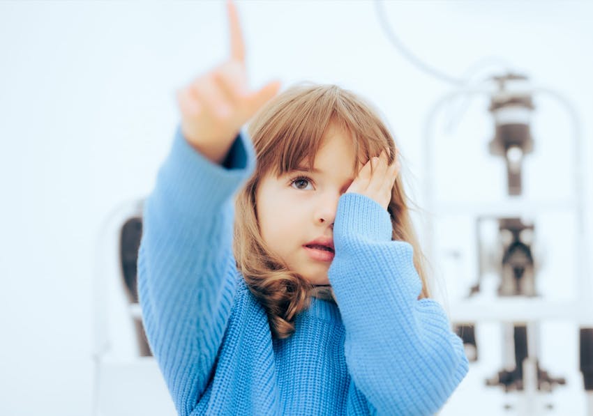 Girl covering one eye and pointing