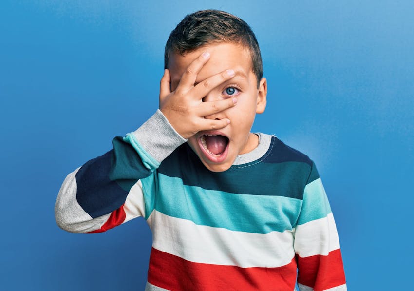 kid covering most of his face with his hand