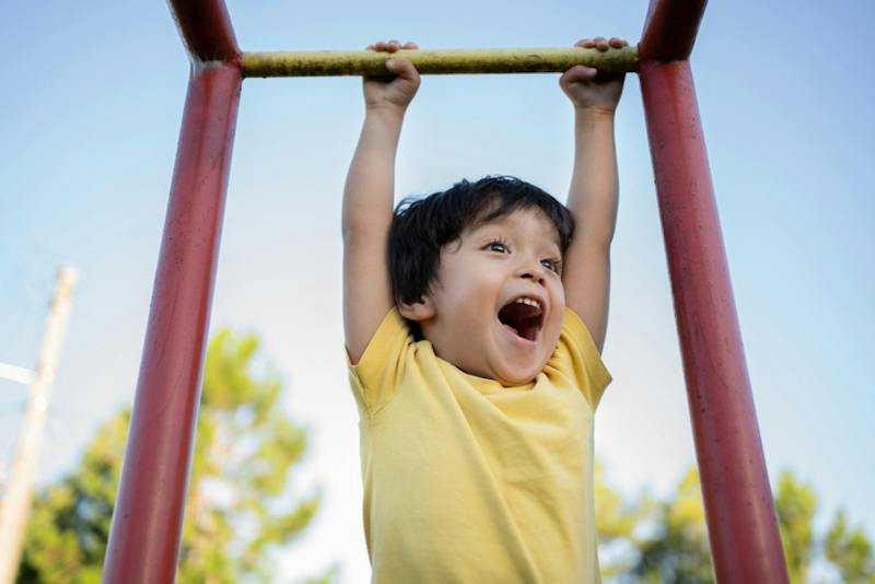 kid swinging on the monkey bars