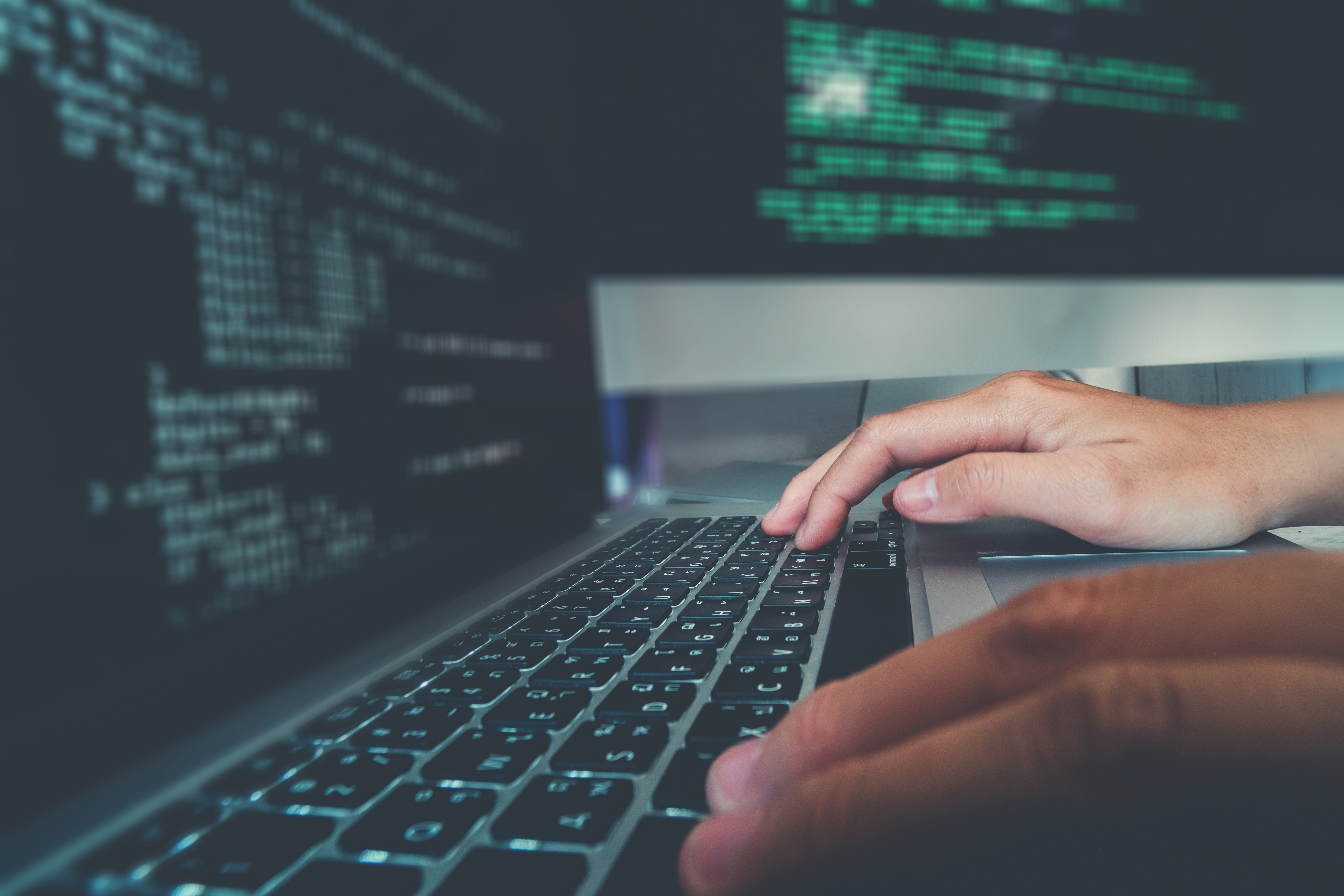 Hands typing on a laptop.