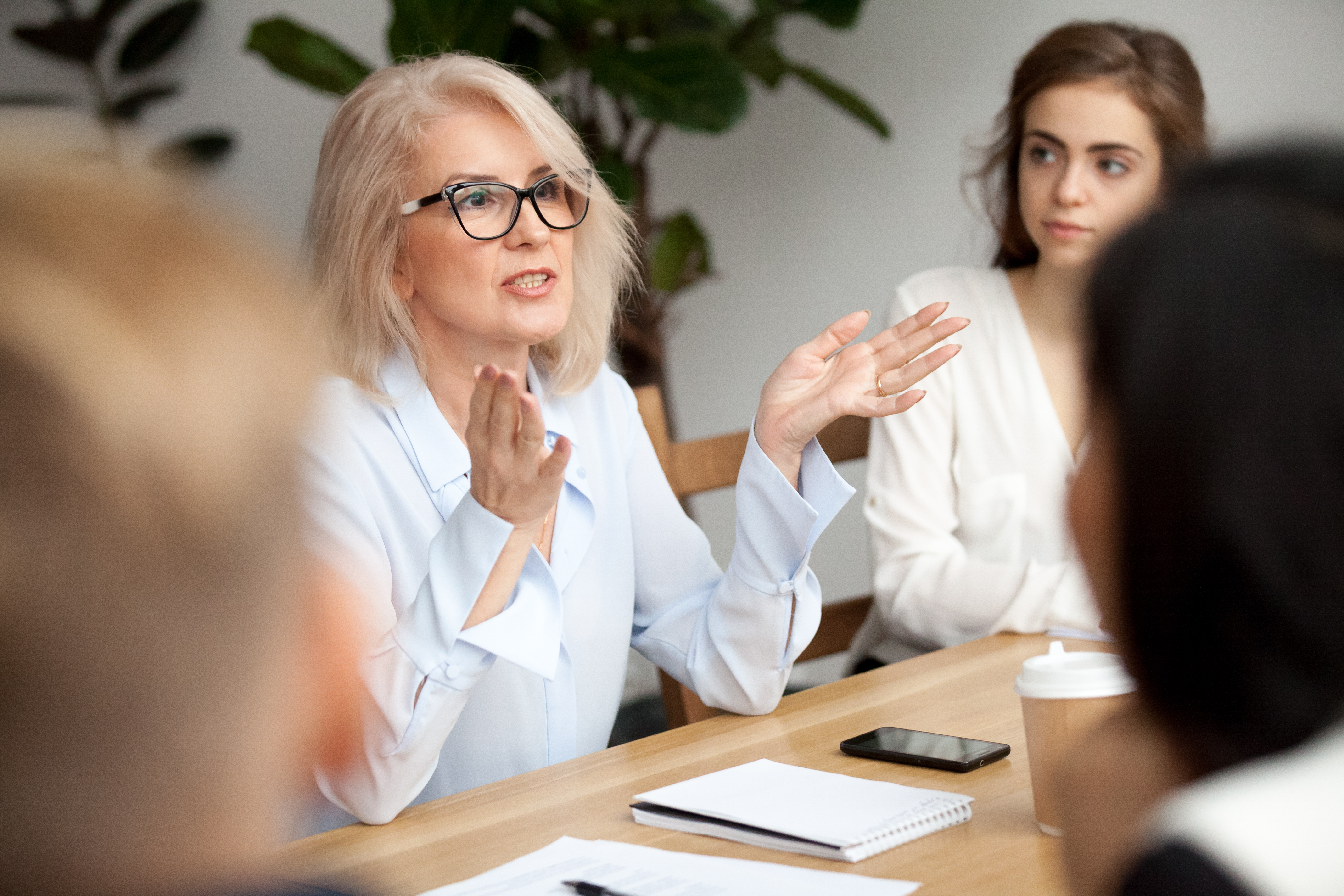 Businesswoman leading a team discussion with confidence during a meeting.
