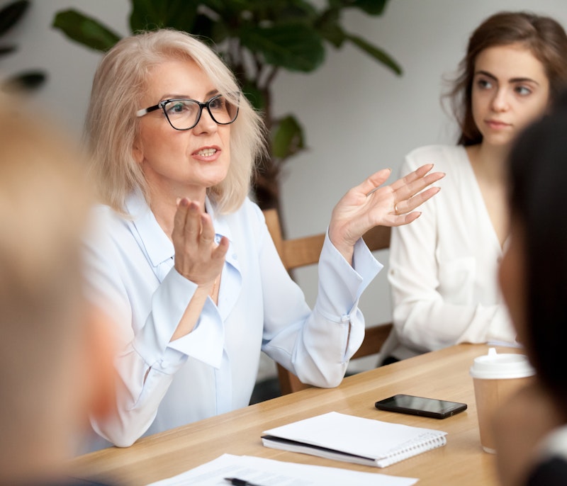 Businesswoman leading a team discussion with confidence during a meeting.