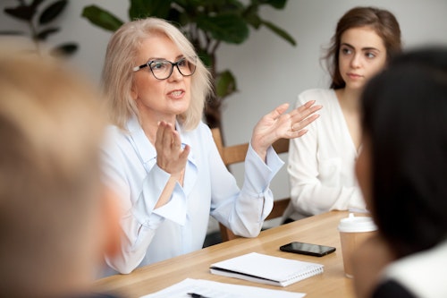 Businesswoman leading a team discussion with confidence during a meeting.