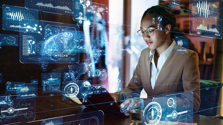 Businesswoman working on a laptop surrounded by futuristic holographic data visualizations and digital analytics interfaces.