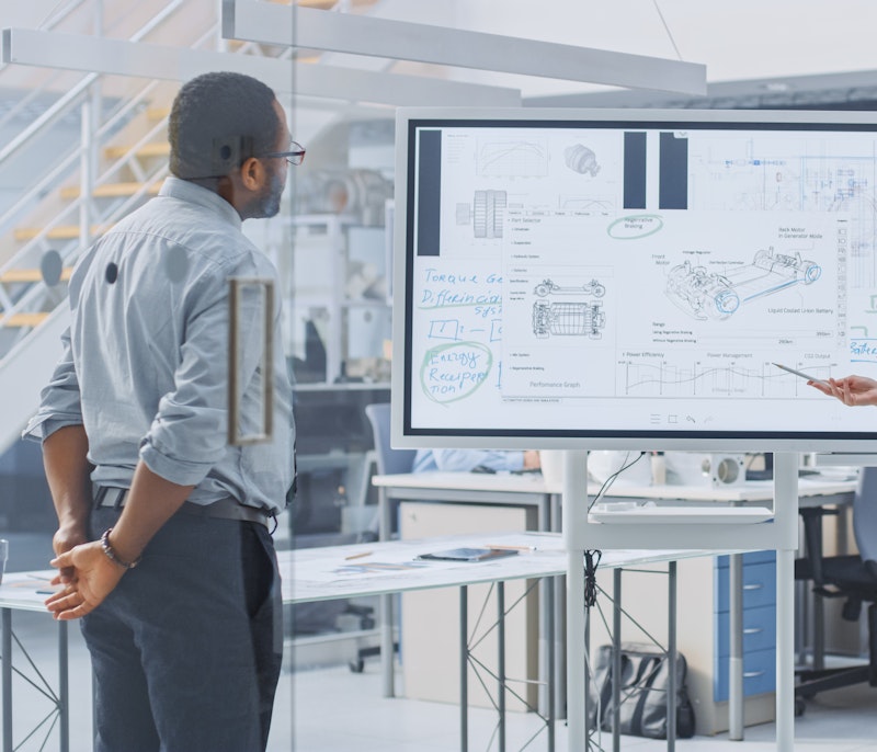 Team workshopping around a whiteboard.