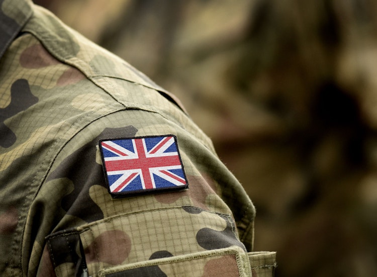 Close-up of a soldier’s camouflage uniform with a Union Jack patch on the shoulder.