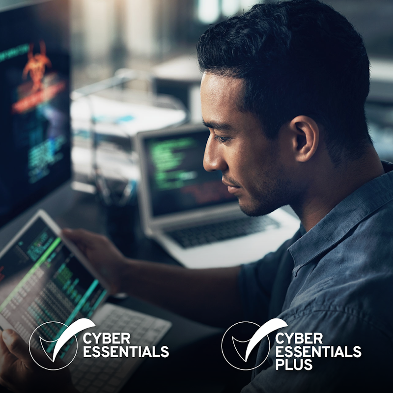 male looking at tablet with cyber info, cyber essentials logo and cyber essentials plus logos in white