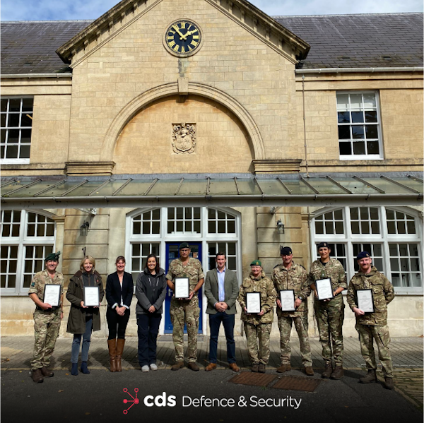 CDS DS trainers in front of sandstone building, joined with Lt Col Steve OCock RIrish - COS AOSB, Caroline West - Supervising Officer AOSB, Natalie Chadwick - CDS DS (Contractor), Vicki Smith - Transcend Awards, Col Iain Moodie - President AOSB, Rod Bell - CDS DS, Lt Col Susie Castle-Smith - AGC(SPS) AOSB Training Officer, Capt Ben Griffiths - RA Group Leader, Maj Tara Sugden - AGC(ETS) Education Advisor, Capt Freddie Phipps - RLC Group Leader