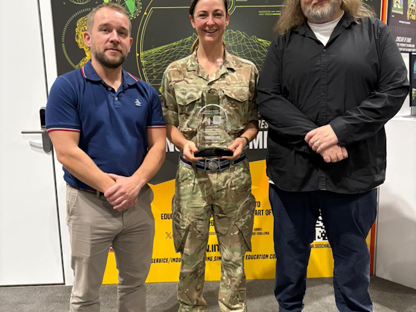 CDS DS employees John Dagger & austen shand along with Major Amanda Willcox-Jones with the Government audience award in front of serious games banner