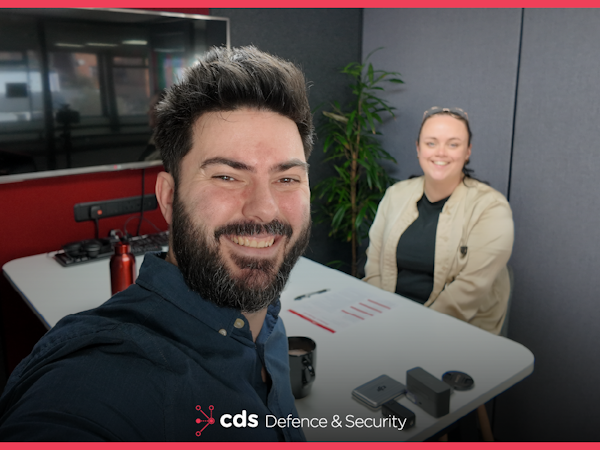 The Briefing Room Episode 7 Podcast host Karl Rees and guest Georgie Henderson smiling towards camera, in the background is a Canon DSLR camera and DJI audio mics.