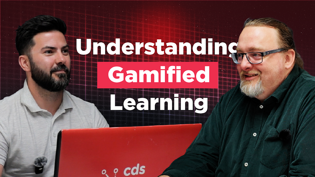 The Briefing Room Episode 9 Thumbnail image for a podcast or video episode titled “Understanding Gamified Learning.” Karl Rees sits on the left in a light grey polo shirt, facing Austen Shand on the right, who is wearing glasses and a dark green shirt. They are seated at a table with a red CDS-branded laptop between them. The background features a dark red digital grid design with large white and pink text displaying the episode title.