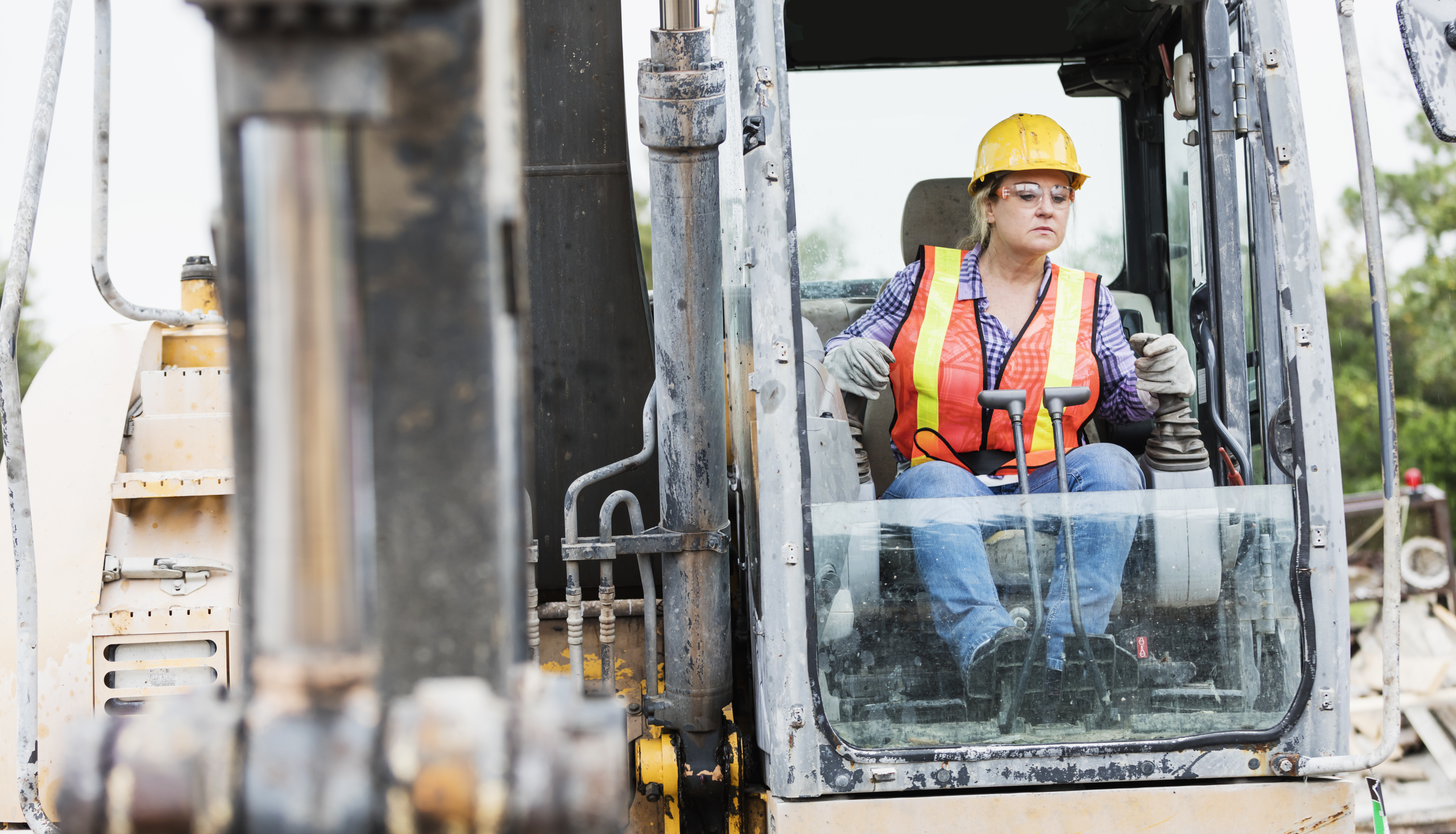 Female construction worker operating equipment