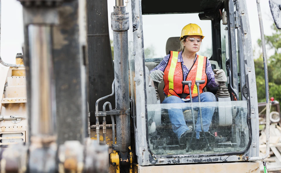 Female construction worker operating equipment