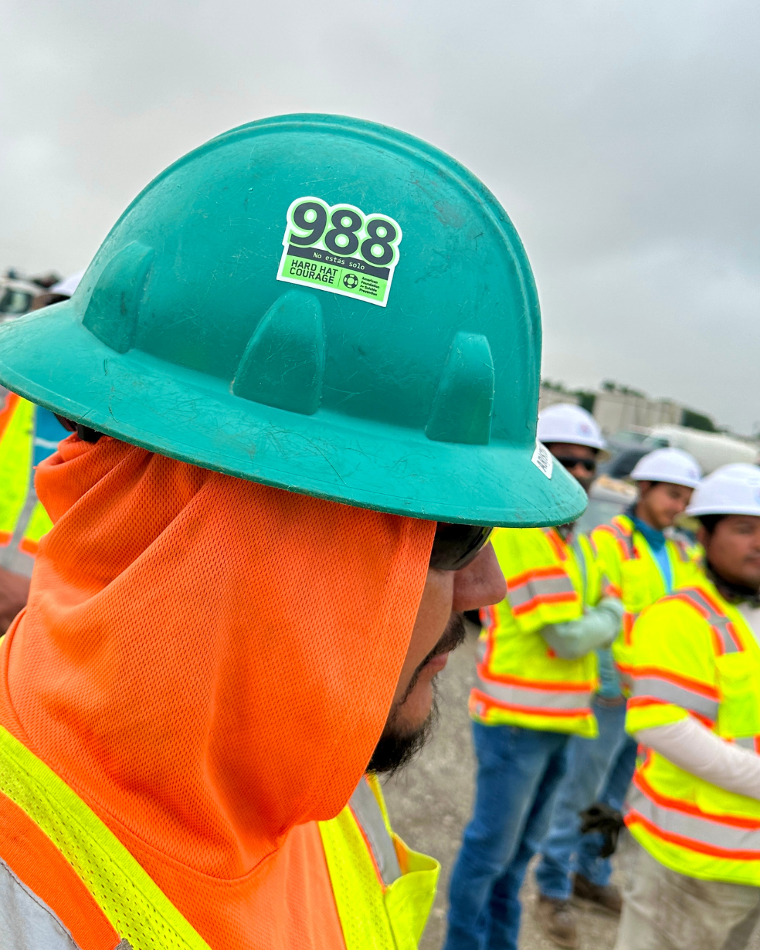 Man wearing hard hat with 988 sticker