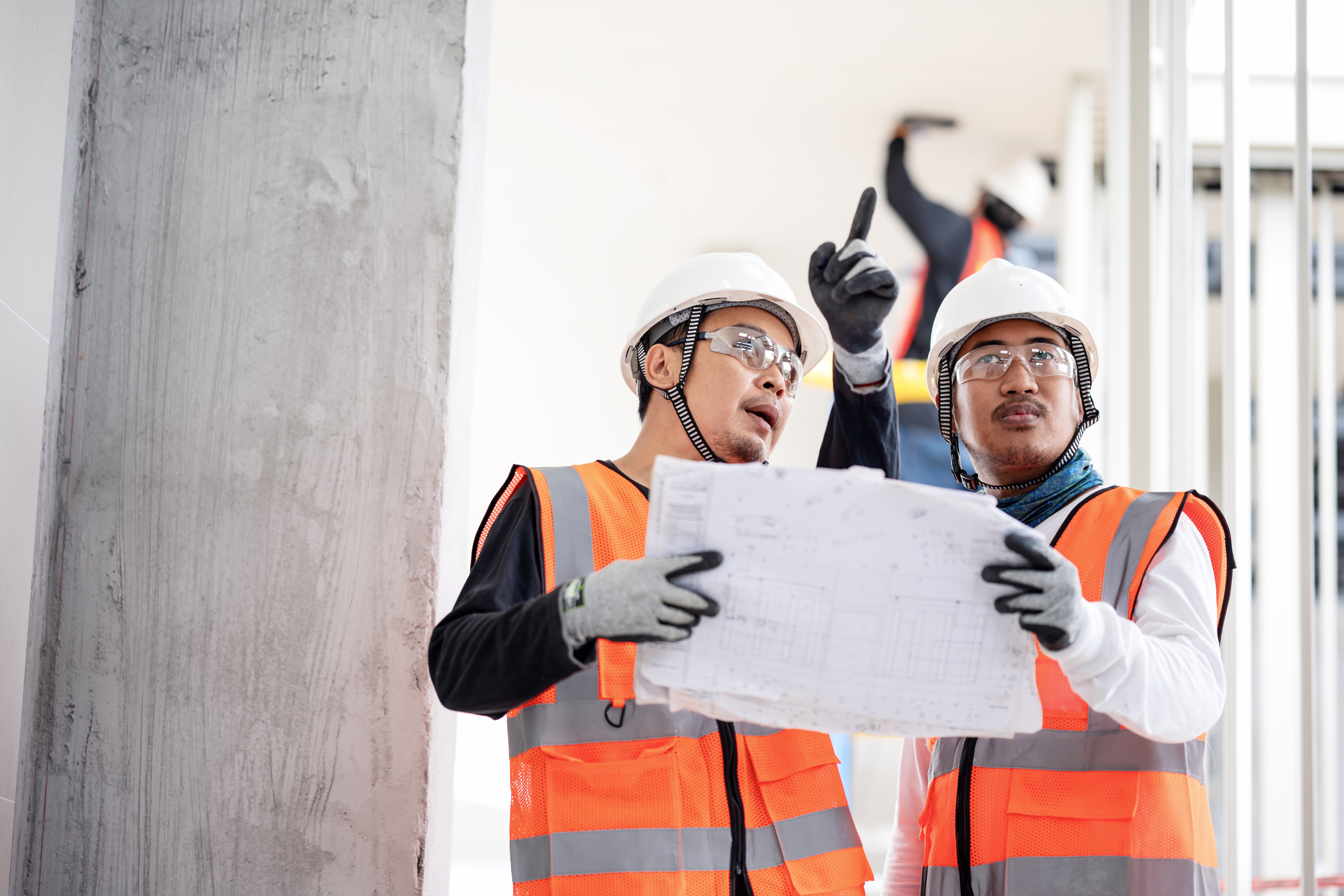 Two construction workers reviewing blueprints