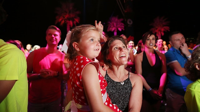 A mother and child watch the fireworks in awe among other spectators.