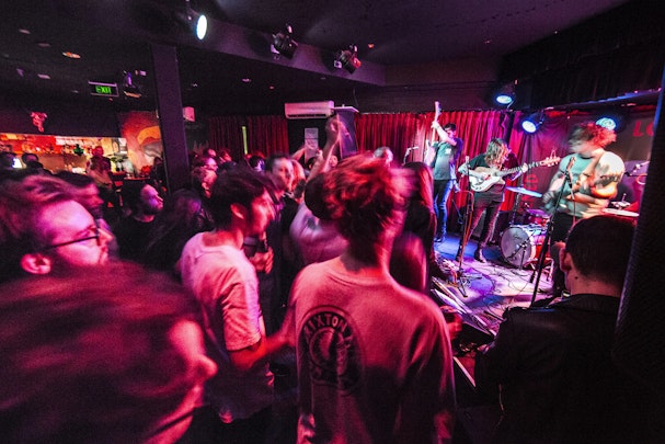 A live band plays to dancing partygoers at an indoor venue.