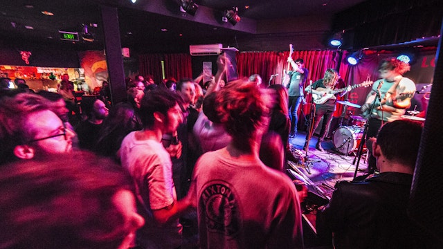 A live band plays to dancing partygoers at an indoor venue.