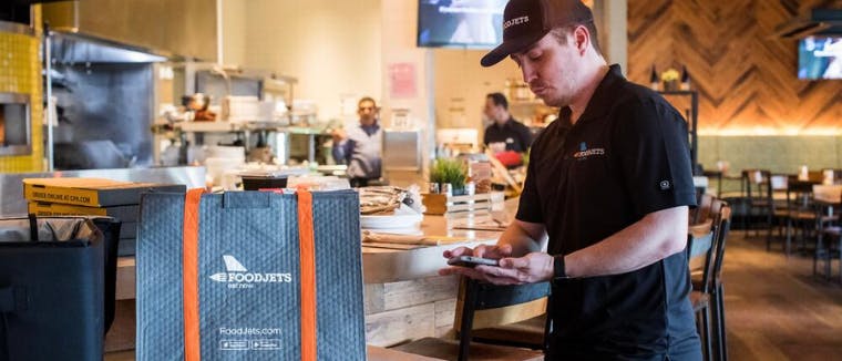 Foodjets courier watching his smartphone