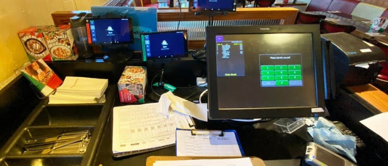 Dark kitchen/ restaurant desk with too many tablets to handle online delivery orders.