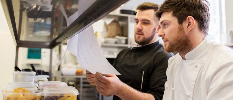 Restaurant staff supervising inventory management in the kitchen