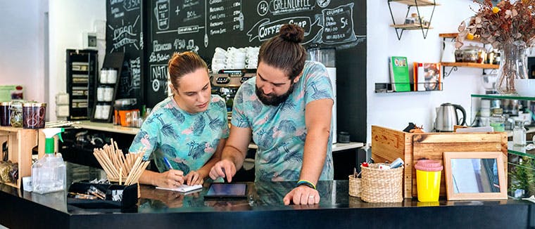 Man and woman talking about business in a coffee shop. Menu price inflation. Deliverect.